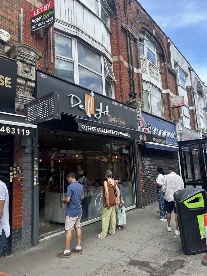 The shopfront on Ballards Lane with passers-by on the pavement