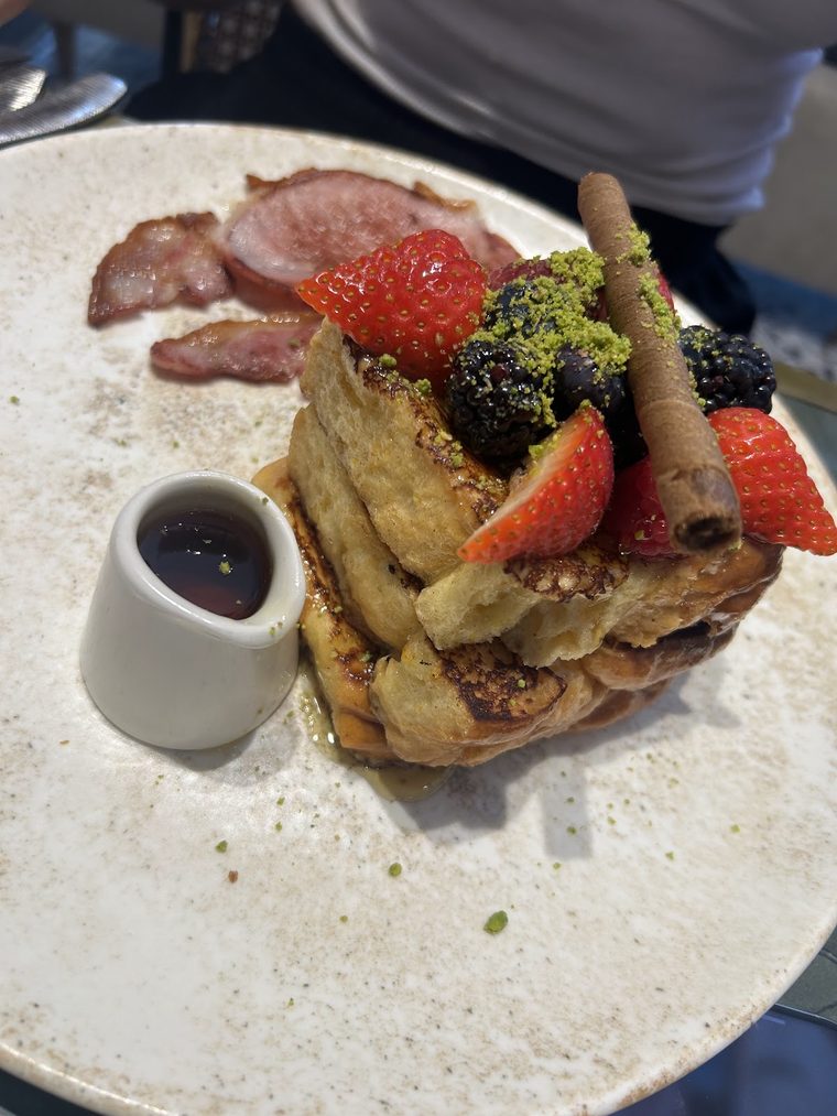 French toast with berries, a wafer roll and bacon